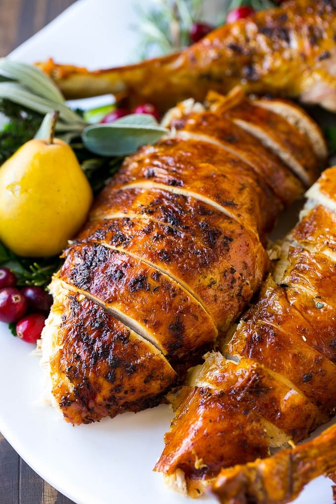 Herb roasted turkey sliced on a platter is the perfect holiday main course.