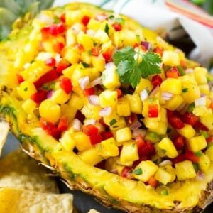 A pineapple boat filled with pineapple salsa.