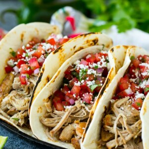 Pork tacos in flour tortillas topped with pico de gallo.