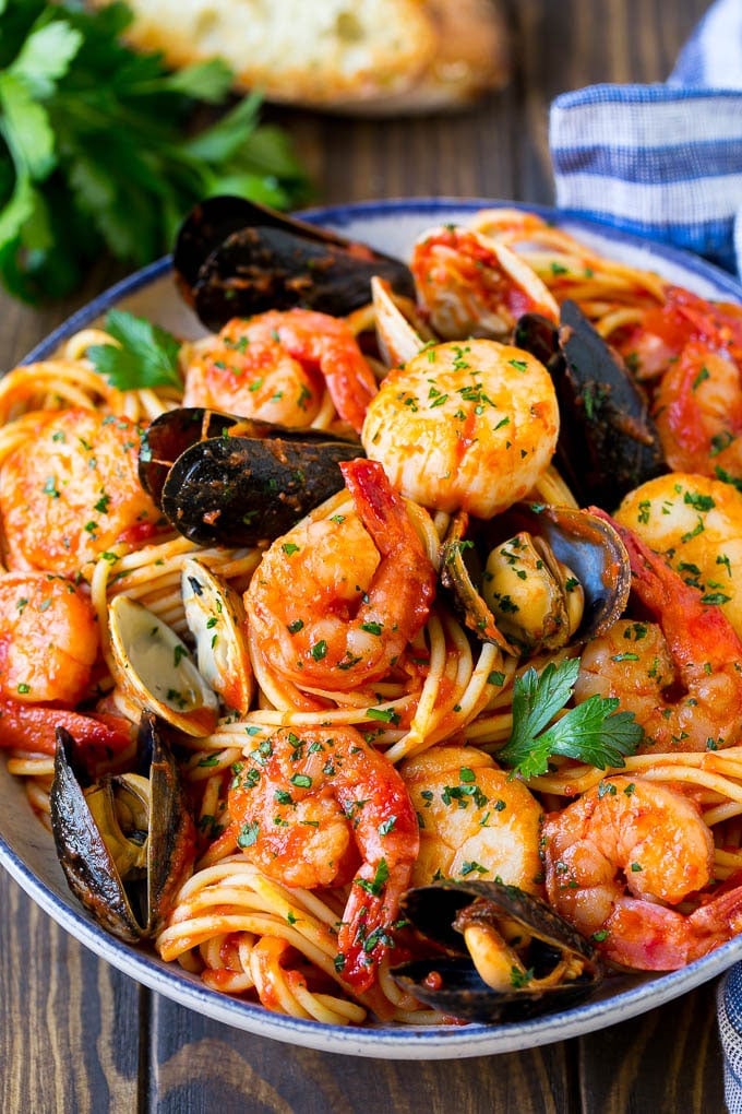 A bowl of seafood pasta with shrimp, clams and scallops.