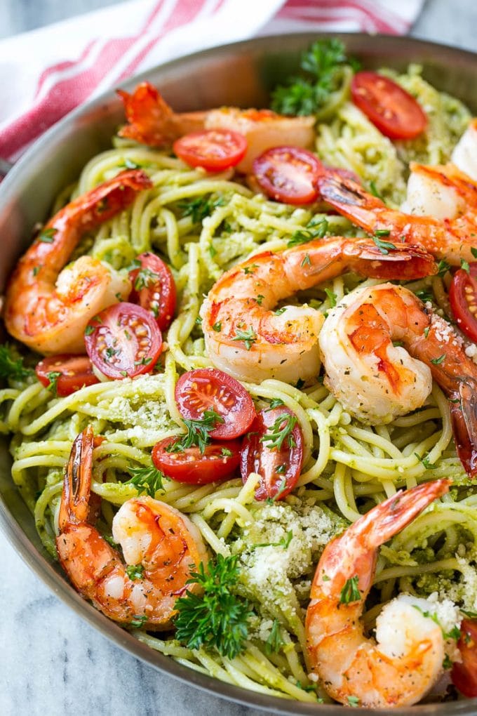 This recipe for shrimp pesto pasta is spaghetti tossed in a flavorful pesto sauce, then topped with sauteed shrimp and tomatoes. A fresh and easy dinner that's quick to make and packed with flavor!